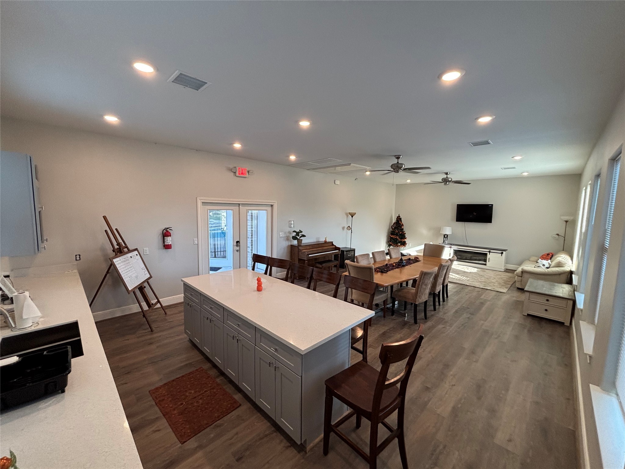 504 Nursery Road, Unit 1209 The Woodlands, TX 77380 - Photo 8 of 27 a large dining hall with stainless steel appliances a sink dishwasher a dining table and chairs with wooden floor