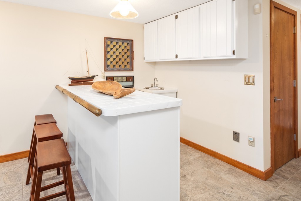 13 Oceanside Drive, Unit 13 Hull, MA 02045 - Photo 16 of 27 a room with a sink and a cabinets