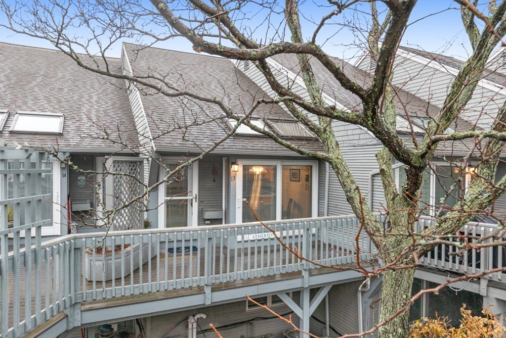 13 Oceanside Drive, Unit 13 Hull, MA 02045 - Photo 22 of 27 a porch with a bench next to a yard