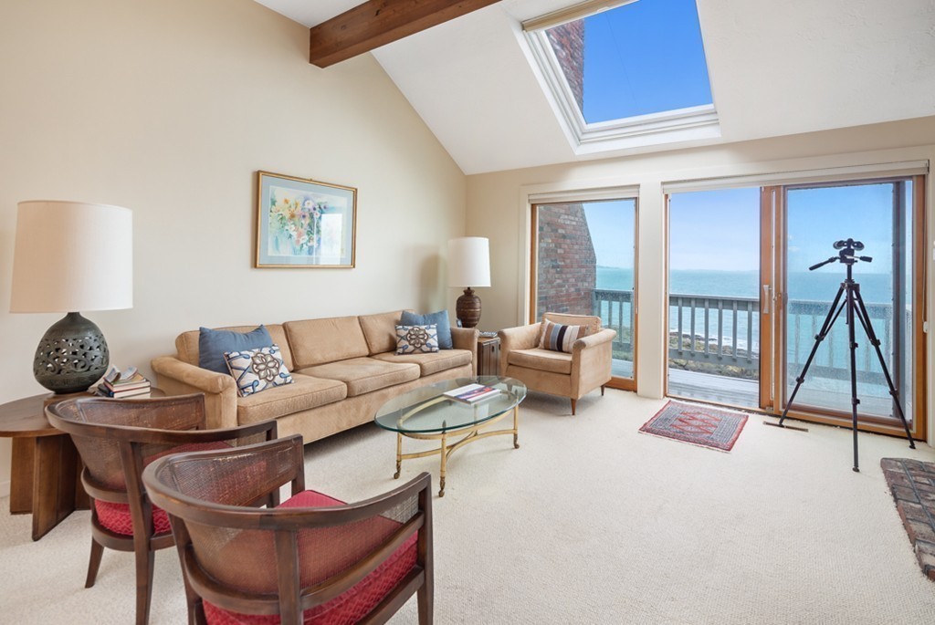 13 Oceanside Drive, Unit 13 Hull, MA 02045 - Photo 5 of 27 a living room with furniture a flat screen tv and a table