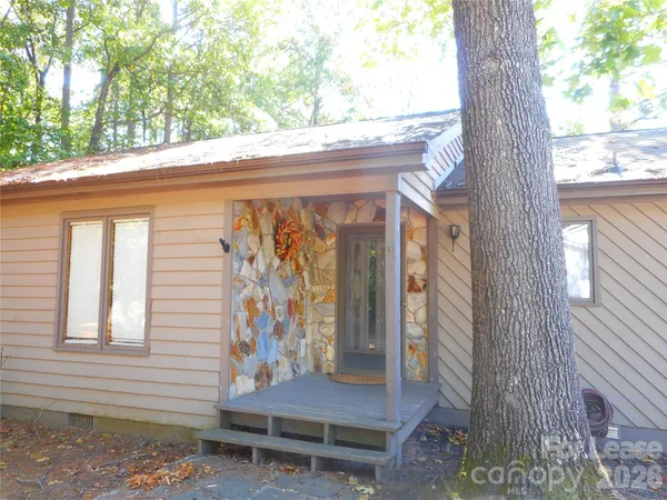 a front view of a house with a tree