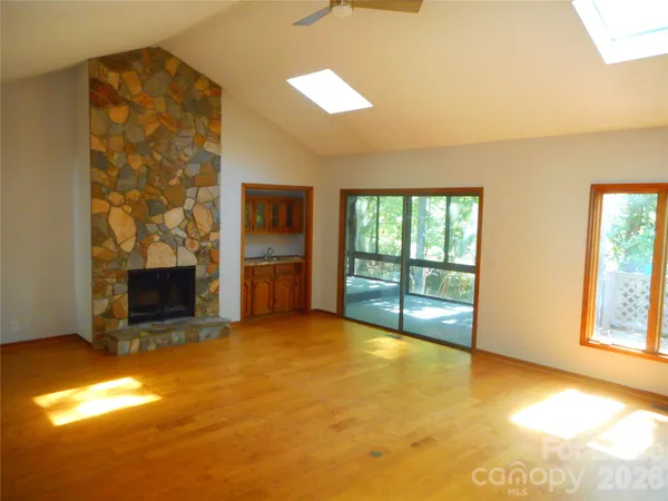 a view of an empty room with a fireplace and a window