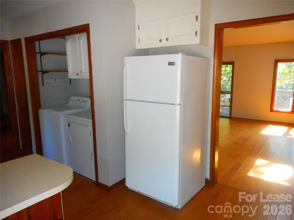 a view of hallway with furniture and a refrigerator