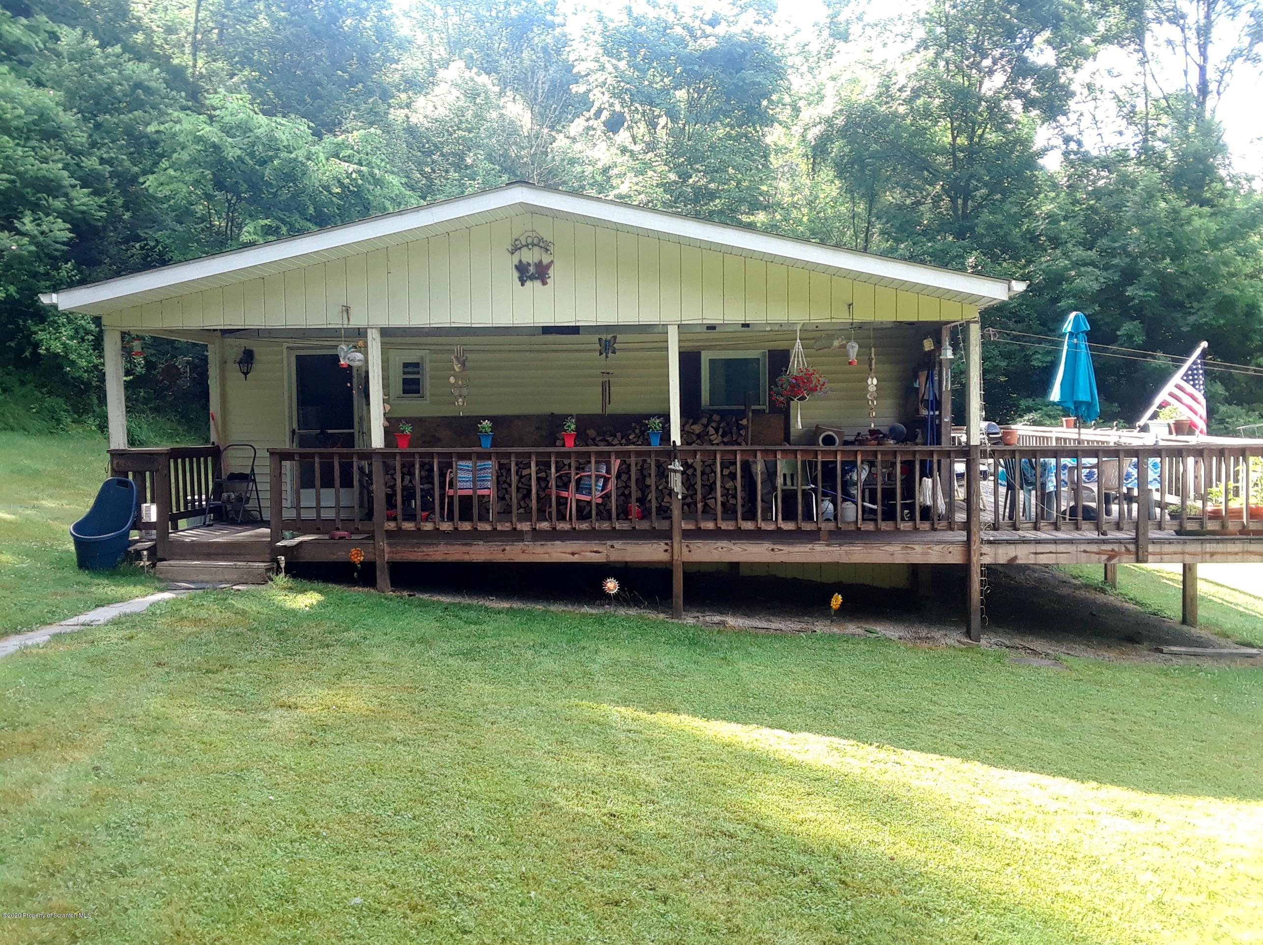 a view of a house with a yard and deck area under a roof deck