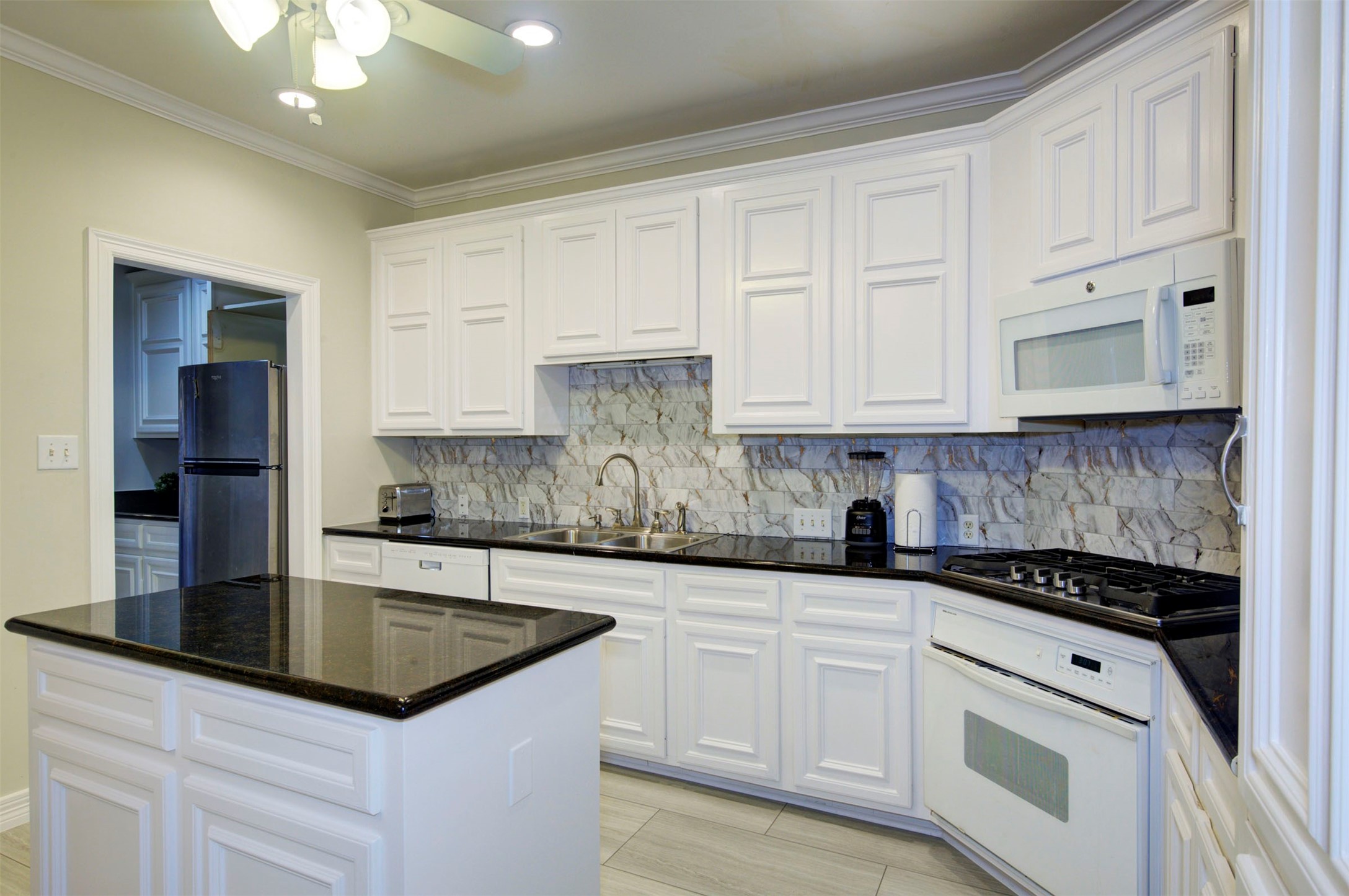1711 Huldy Street, Unit A Houston, TX 77019 - Photo 2 of 38 a kitchen with kitchen island granite countertop a sink a stove and cabinets