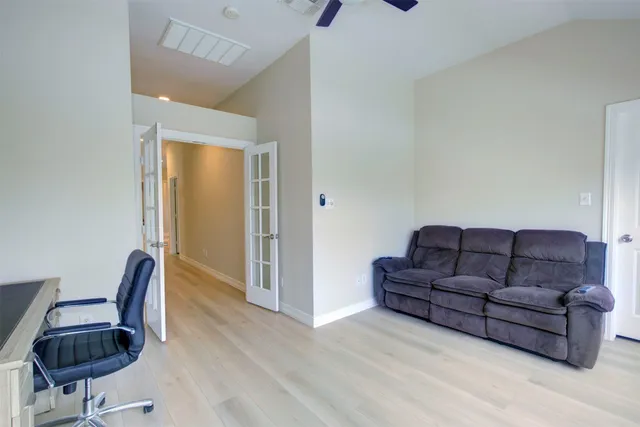 a view of a hallway with wooden floor and a bathroom