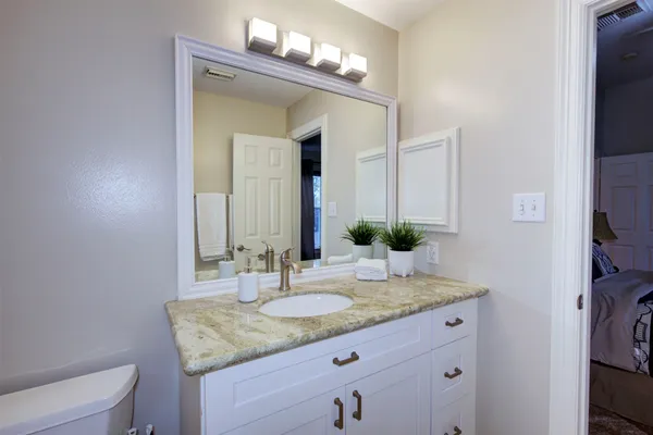 a bathroom with a granite countertop sink and a mirror