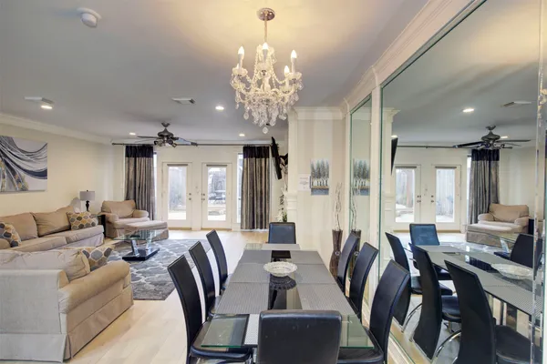 a view of a dining room with furniture a chandelier and wooden floor