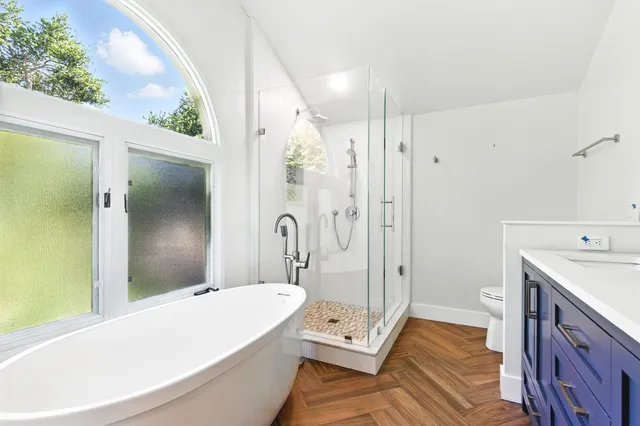 a bathroom with a tub shower and sink