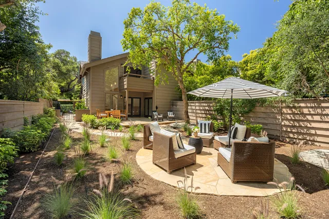 a view of a patio with table and chairs under an umbrella