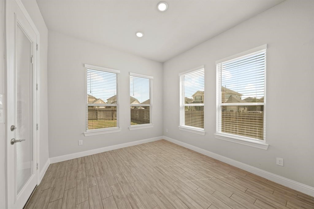 31302 Quartet Court Fulshear, TX 77441 - Photo 14 of 32 an empty room with wooden floor and windows