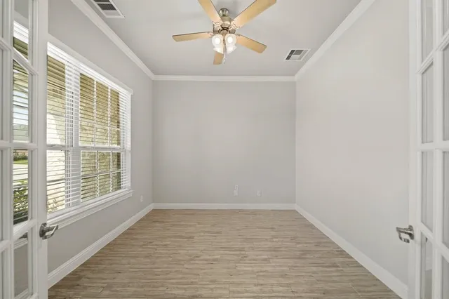 an empty room with wooden floor fireplace and windows