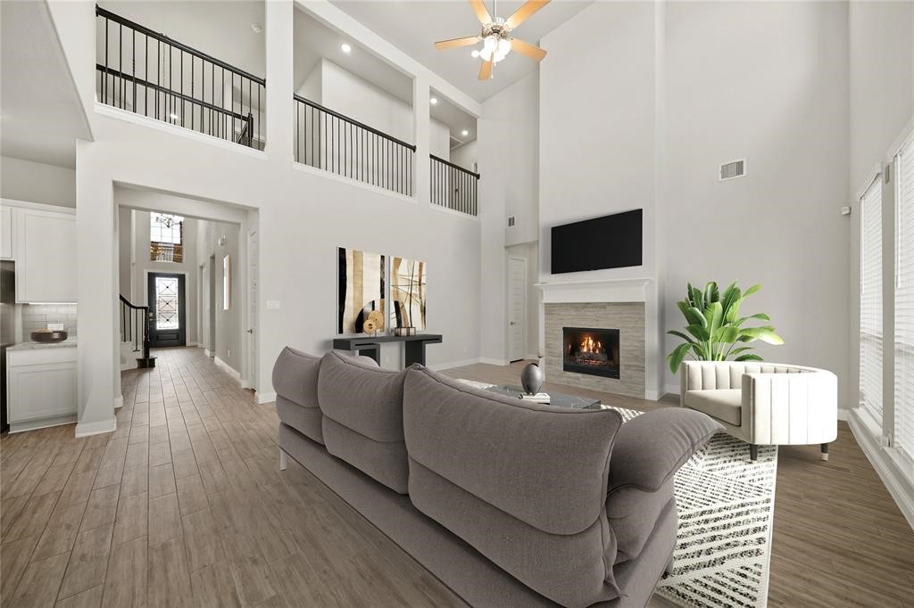 31302 Quartet Court Fulshear, TX 77441 - Photo 9 of 32 a living room with furniture a flat screen tv and a fireplace