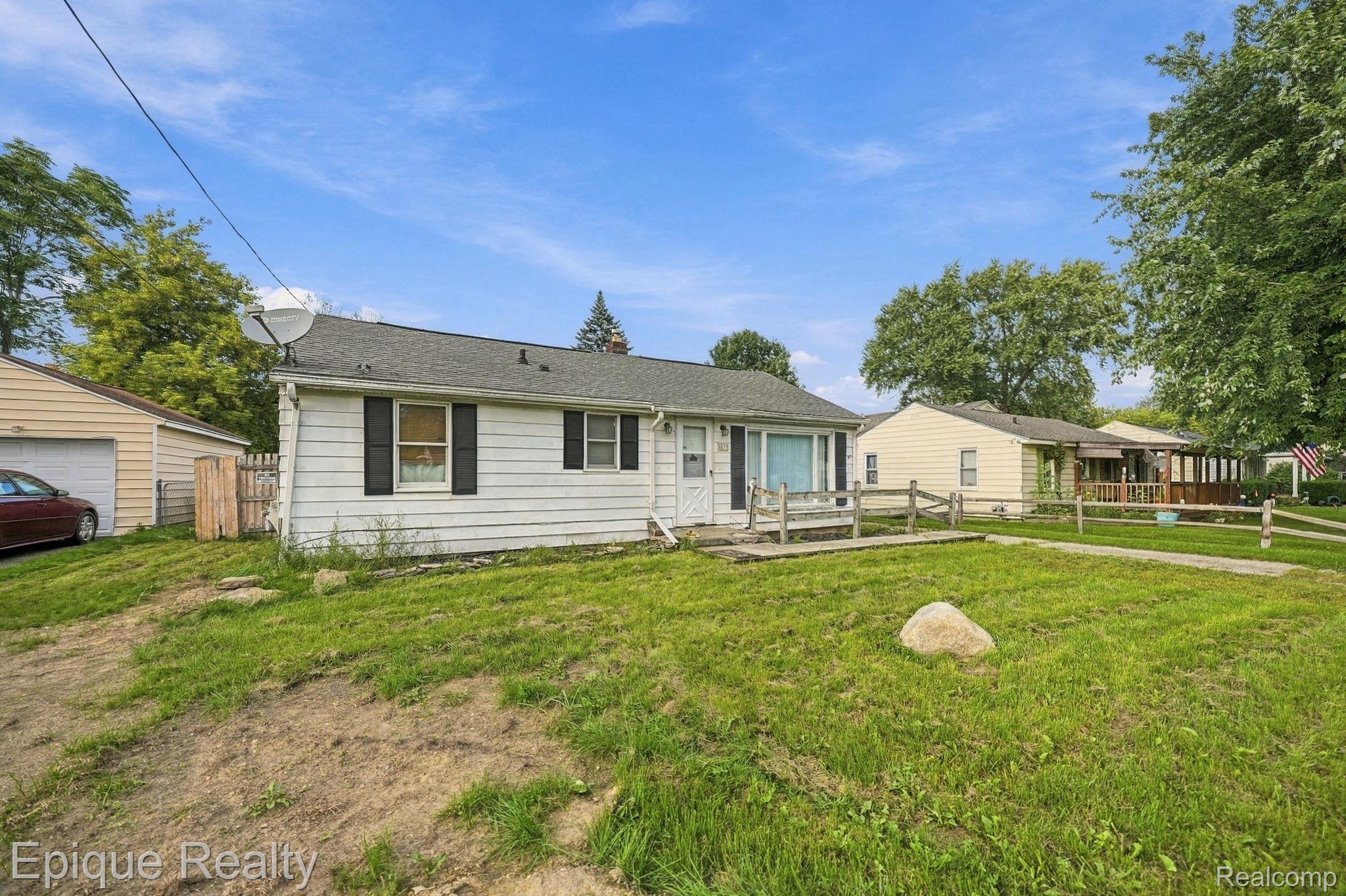 4033 Risedorph Street Burton, MI 48509 - Photo 2 of 25 White siding exterior with black window shutters and a gabled roof