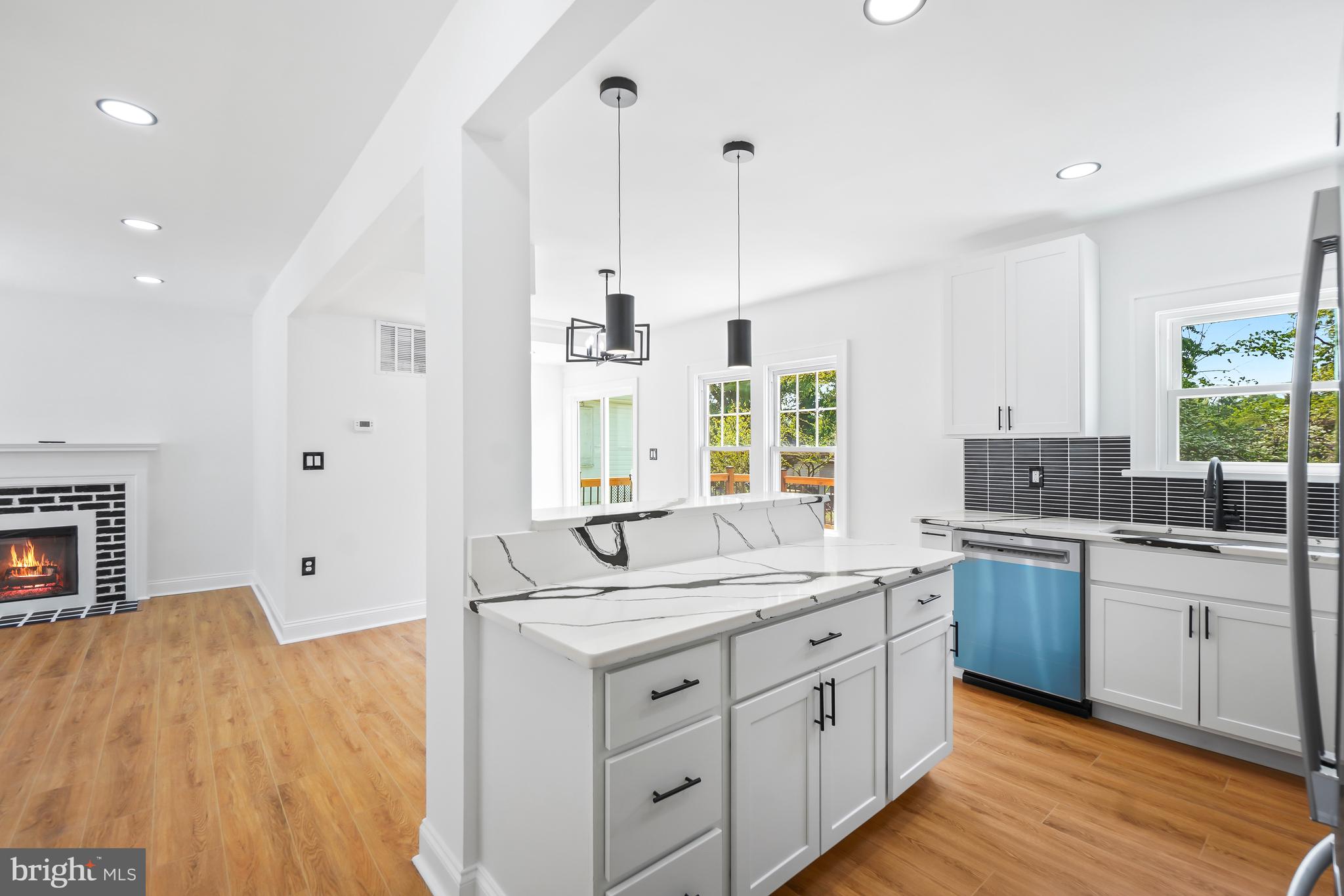 5309 Chesapeake Road Hyattsville, MD 20781 - Photo 14 of 36 a large white kitchen with a stove a sink a chimney wooden floor and cabinets