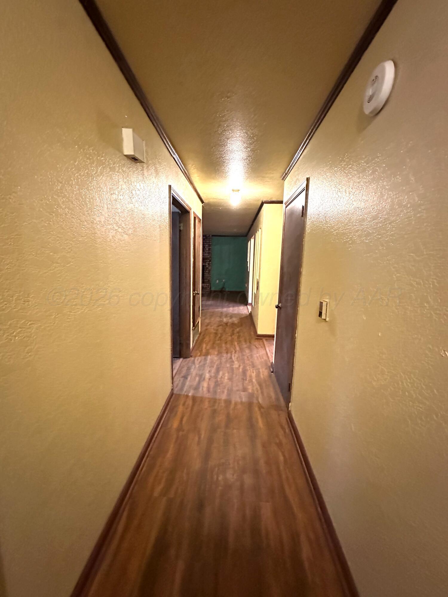 7811 Highway 86 Tulia, TX 79088 - Photo 13 of 19 a view of a hallway with wooden floor