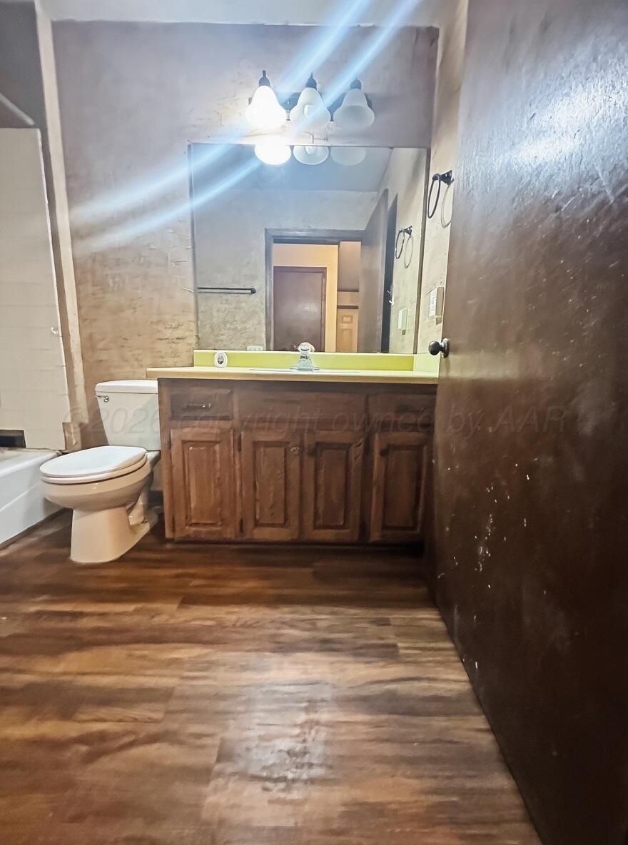 7811 Highway 86 Tulia, TX 79088 - Photo 14 of 19 a bathroom with a toilet a sink a mirror a window and vanity