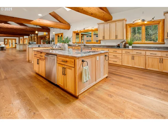a large kitchen with stainless steel appliances granite countertop a stove and a sink