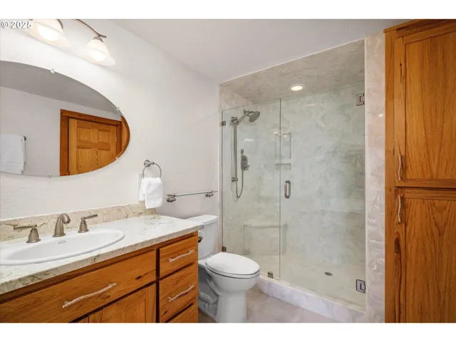 a bathroom with a granite countertop sink a large mirror and a bathtub
