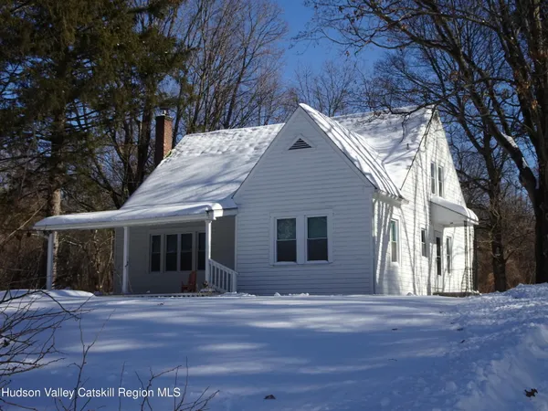 a front view of house with yard and trees around