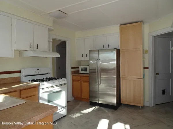 a kitchen with stainless steel appliances granite countertop a refrigerator a stove and a sink