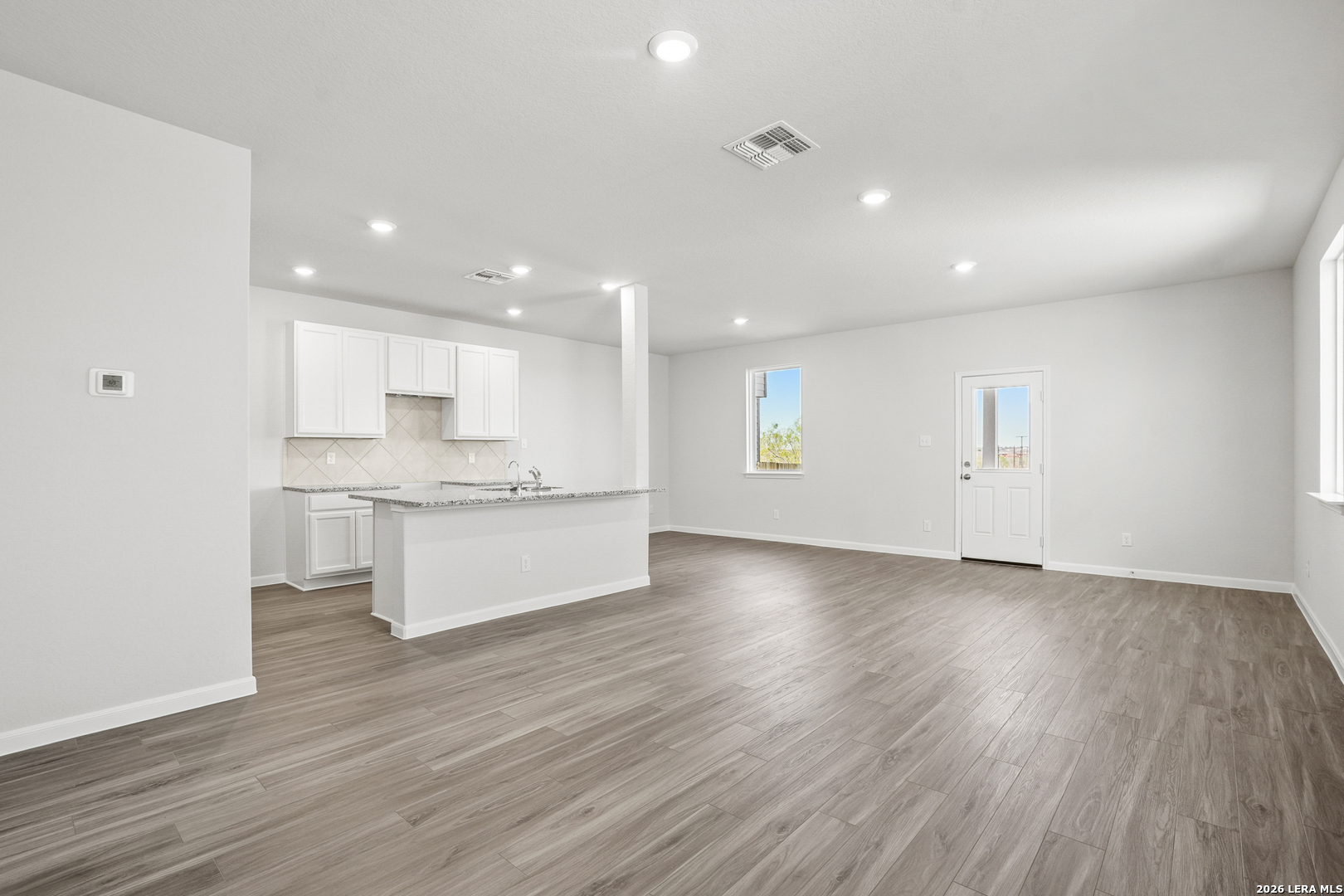 11111 Luckenbach Loop Converse, TX 78109 - Photo 4 of 27 a view of kitchen with wooden floor and window