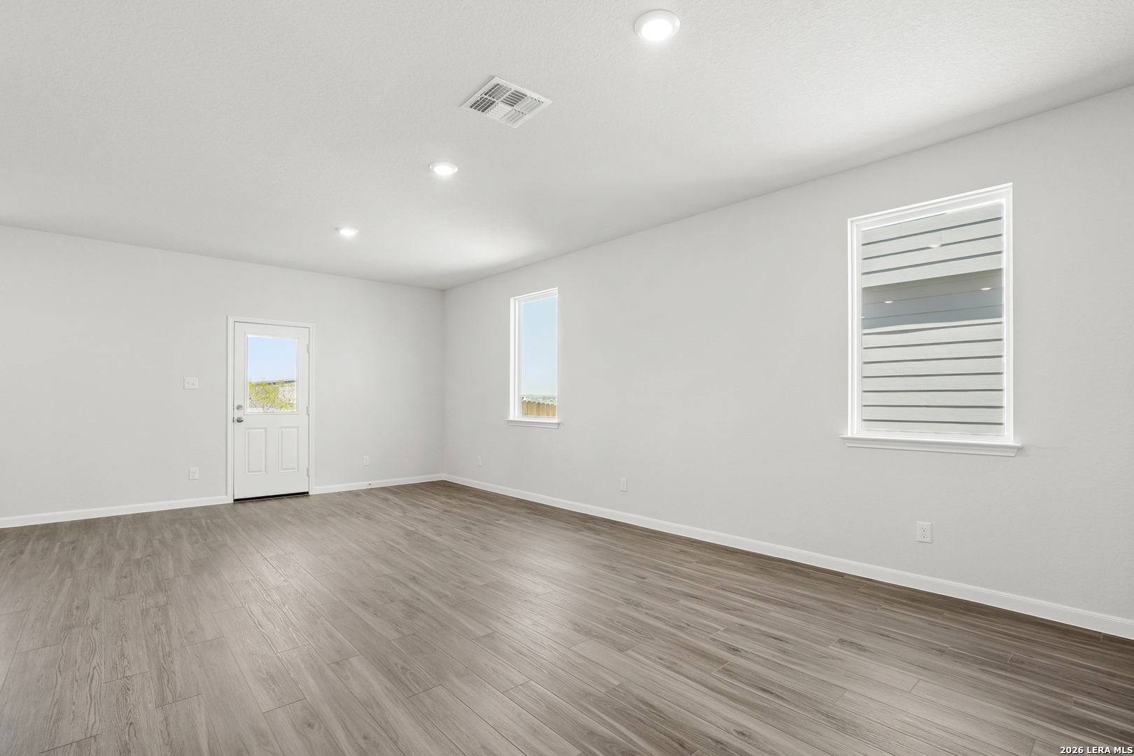 11111 Luckenbach Loop Converse, TX 78109 - Photo 5 of 27 an empty room with wooden floor and windows