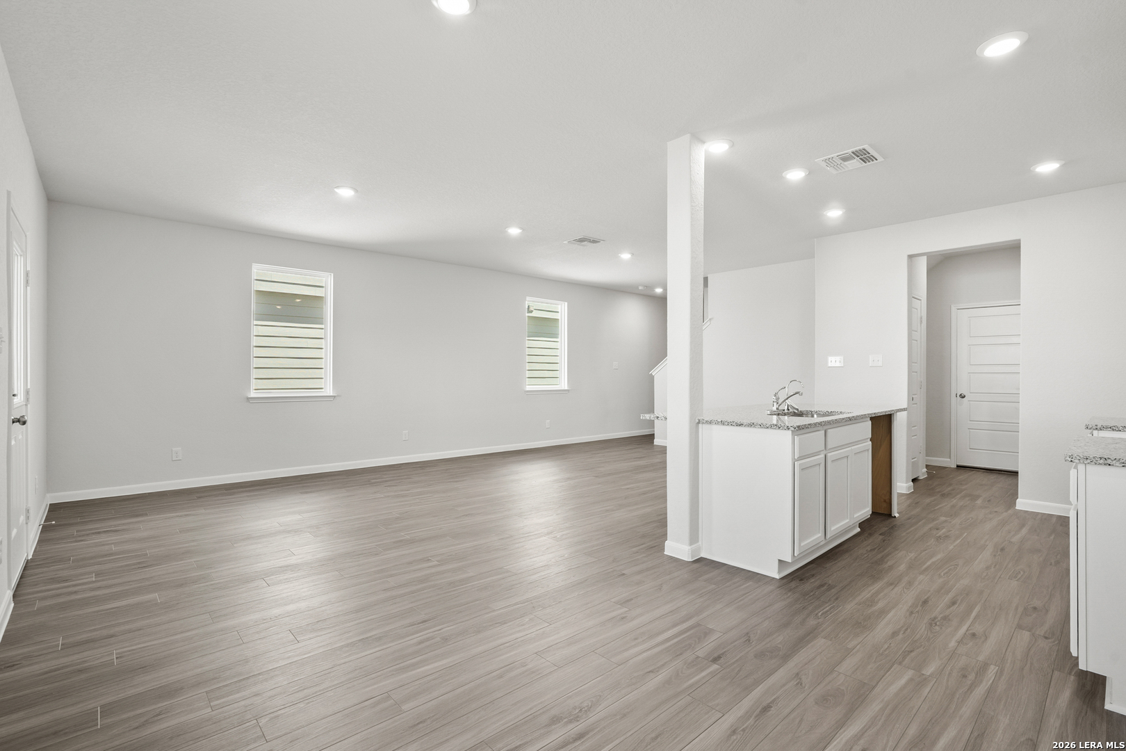 11111 Luckenbach Loop Converse, TX 78109 - Photo 7 of 27 an empty room with wooden floor and windows