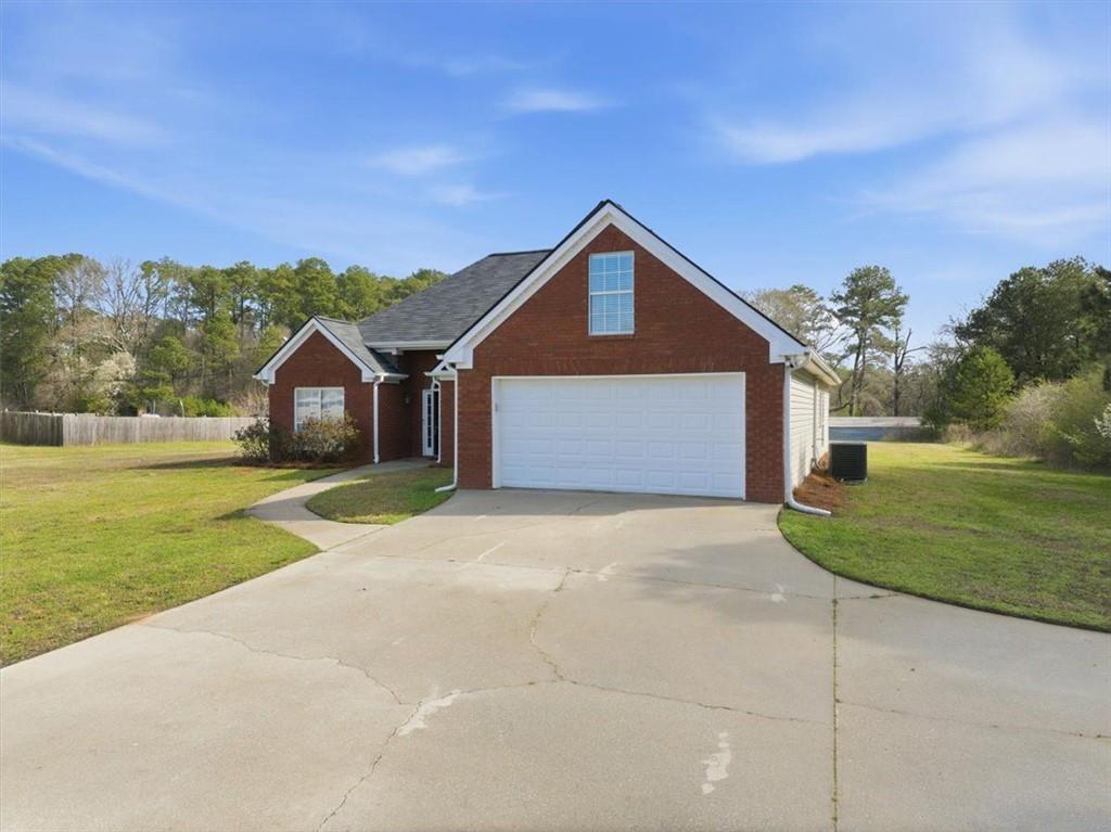493 Youth Jersey Road Covington, GA 30014 - Photo 4 of 52 a front view of a house with a yard and garage