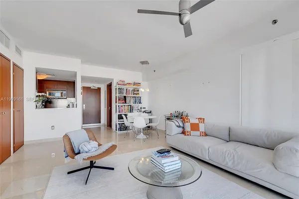 a living room with furniture a rug and a bookshelf