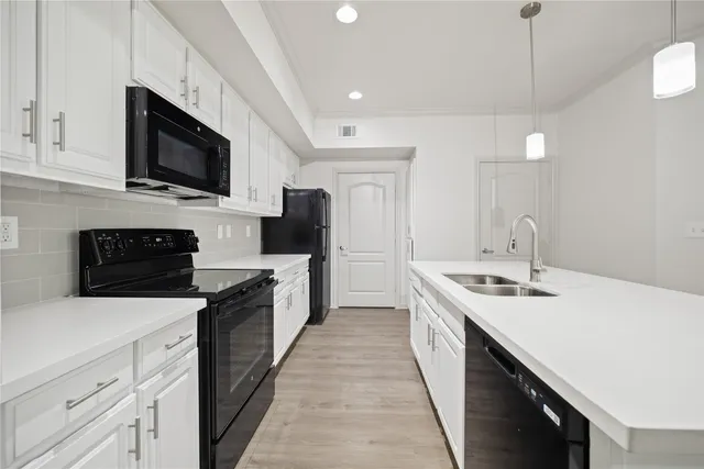 a kitchen with stainless steel appliances a sink dishwasher stove top oven and refrigerator