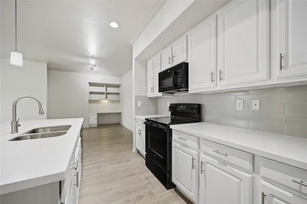 a kitchen with appliances a sink and cabinets