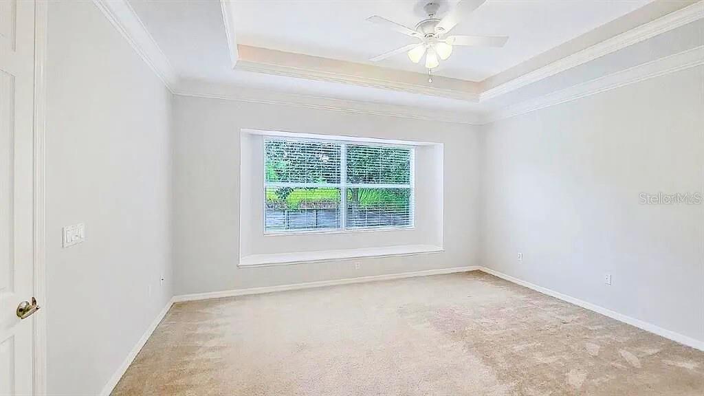 6055 Wingspan Way Bradenton, FL 34203 - Photo 16 of 32 an empty room with a chandelier fan and windows