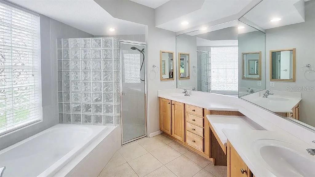 6055 Wingspan Way Bradenton, FL 34203 - Photo 24 of 32 a spacious bathroom with a tub sink and mirror