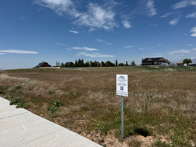 586 West Diamond Rdg Drive Mapleton, UT 84664 - Photo 2 of 4 Expansive undeveloped land parcel featuring a visible lot marker and a concrete sidewalk bordering the property