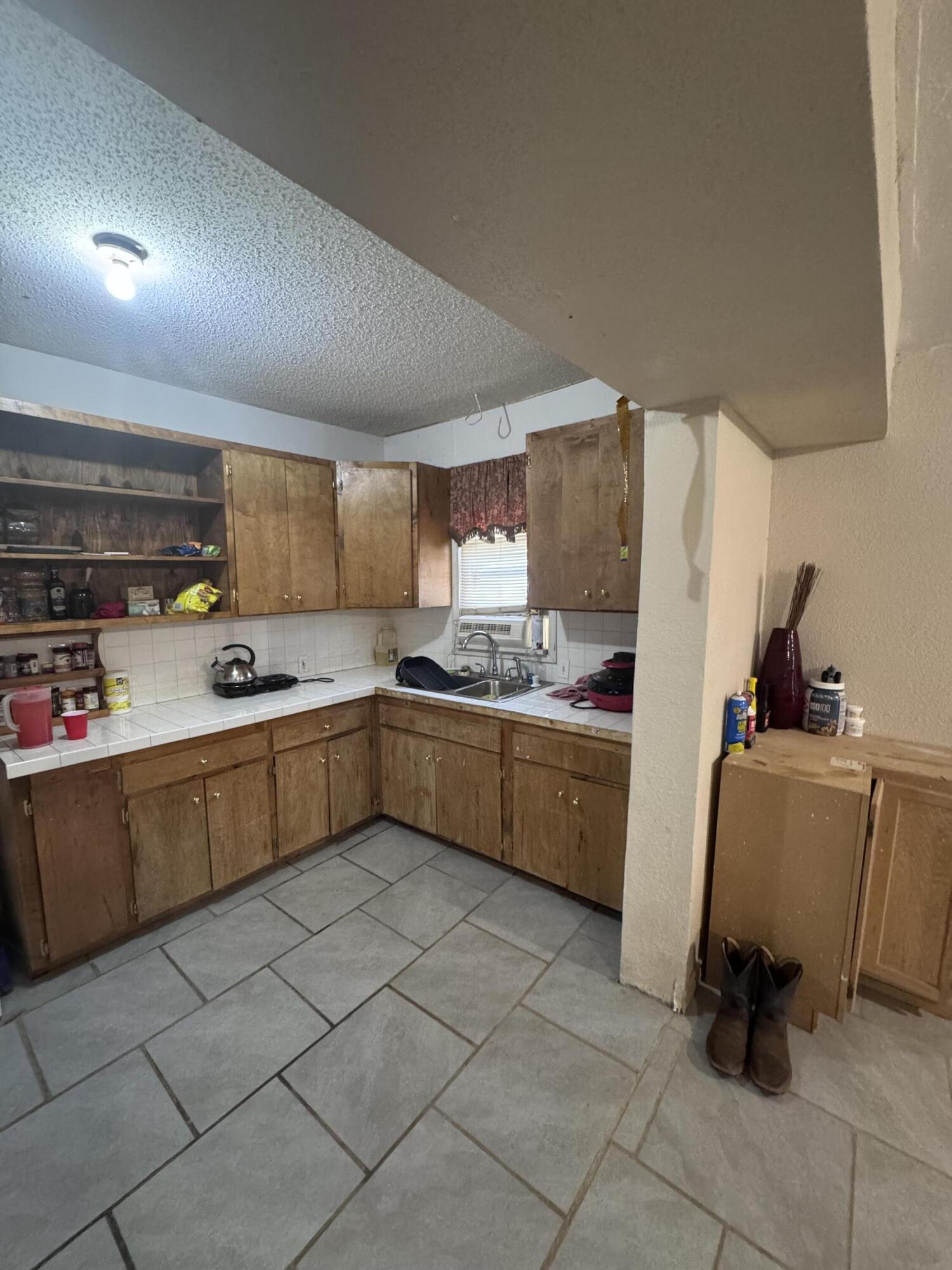 1401 South Canyon Avenue Lamesa, TX 79331 - Photo 16 of 32 a kitchen with a sink window and cabinets