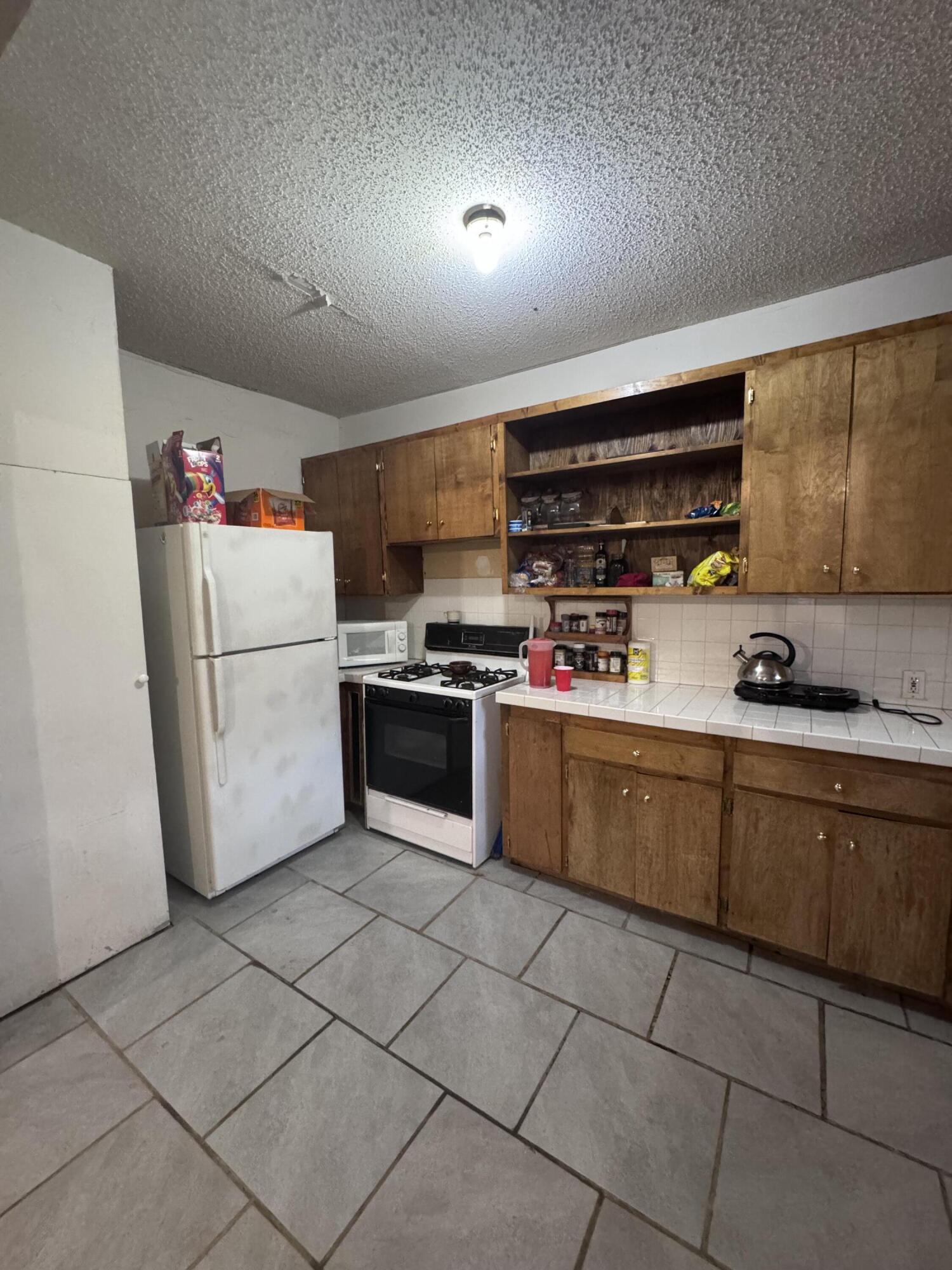 1401 South Canyon Avenue Lamesa, TX 79331 - Photo 17 of 32 a kitchen with cabinets and white appliances