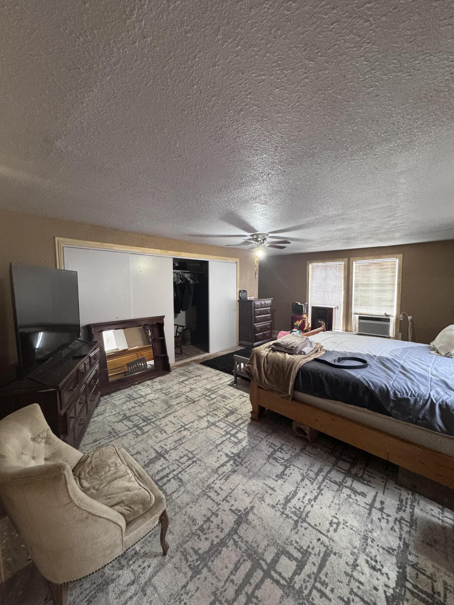 1401 South Canyon Avenue Lamesa, TX 79331 - Photo 25 of 32 a spacious bedroom with a bed and a couch