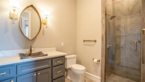 a bathroom with a sink a toilet and a mirror