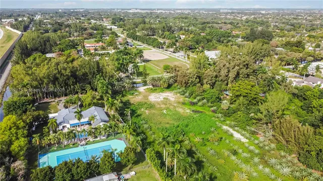 an aerial view of residential houses with outdoor space and trees