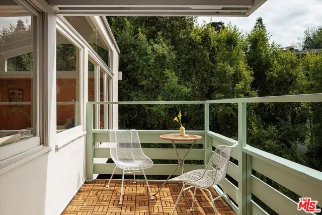 a balcony with wooden floor and outdoor view