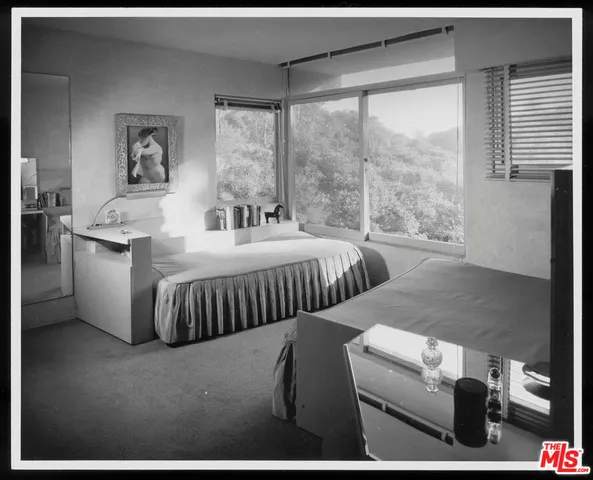 a bedroom with furniture and a large window