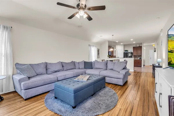 a living room with furniture and a wooden floor
