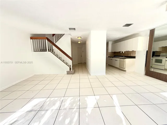 a kitchen with stainless steel appliances granite countertop a refrigerator a sink and white cabinets