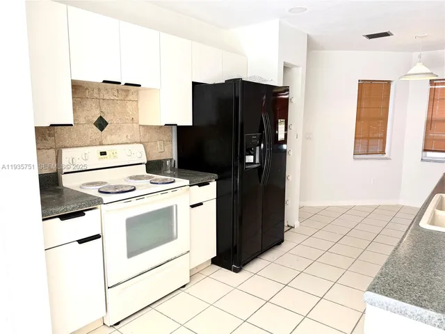 a kitchen with a sink a counter top space and stainless steel appliances