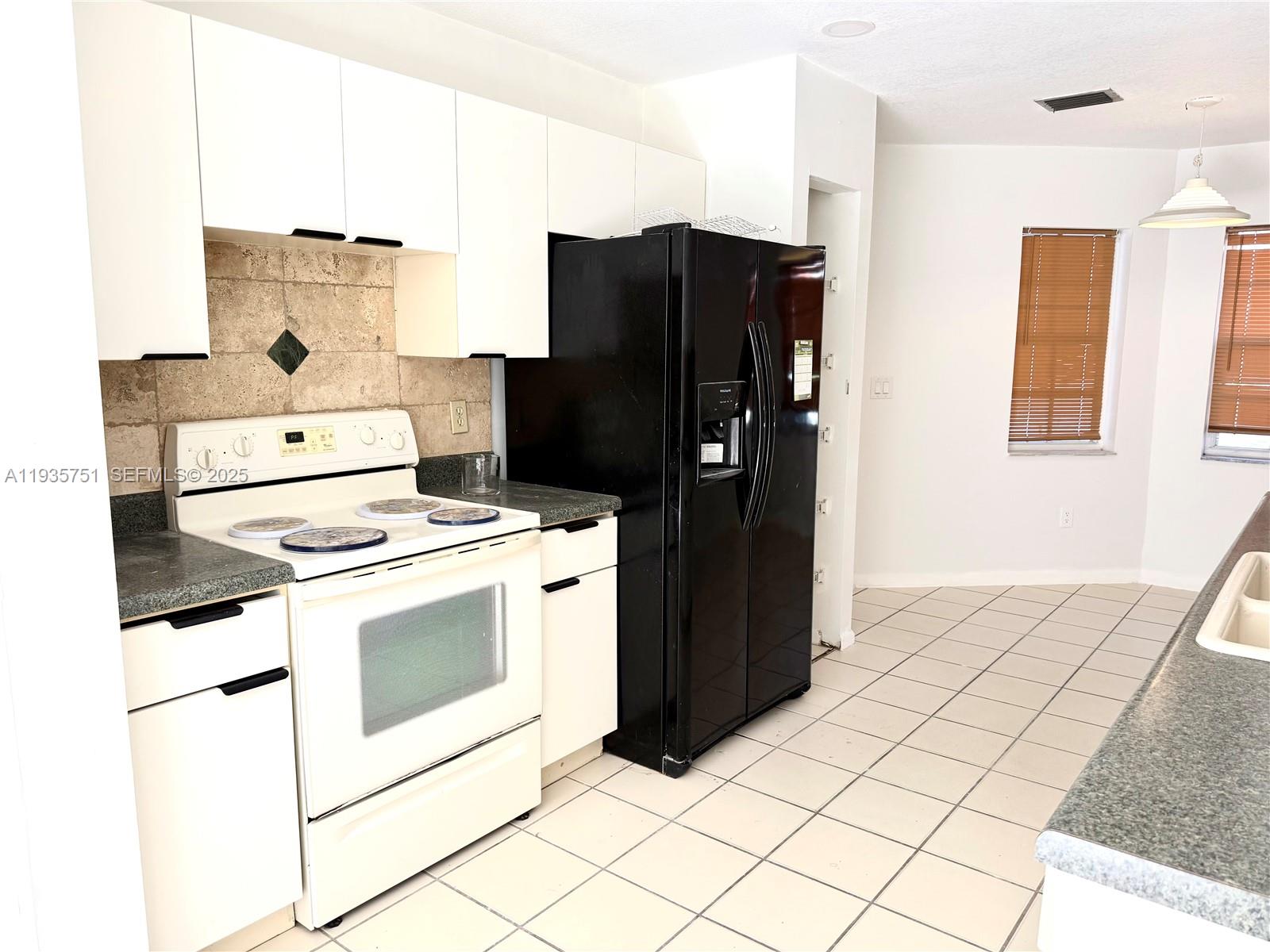 13922 Southwest 102nd Lane Miami, FL 33186 - Photo 5 of 20 a kitchen with a stove top oven and cabinets