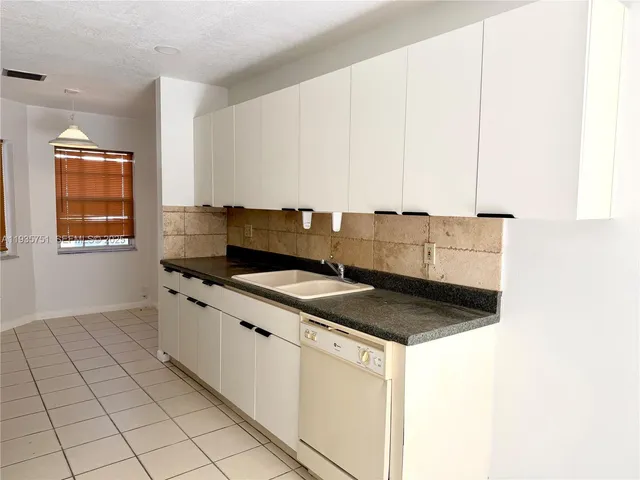 a view of an empty room with window and cabinet