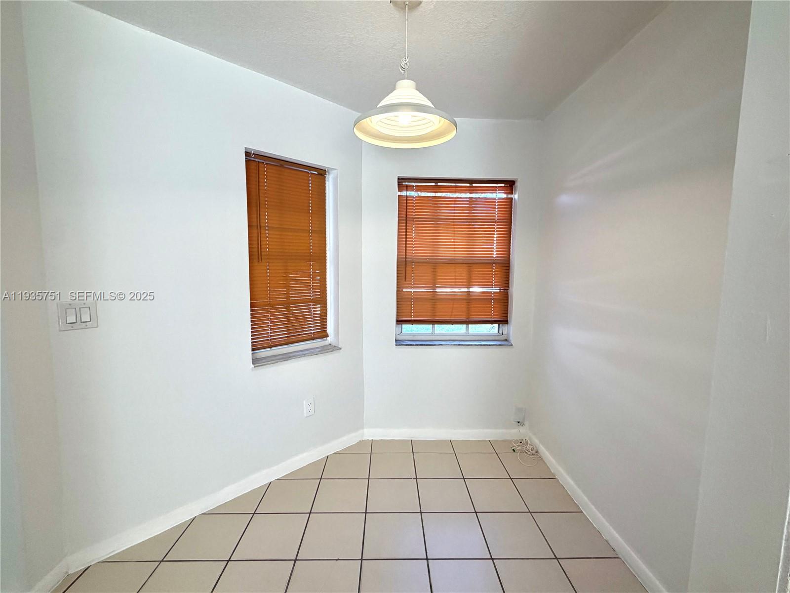 13922 Southwest 102nd Lane Miami, FL 33186 - Photo 9 of 20 a view of an empty room with window and chandelier fan