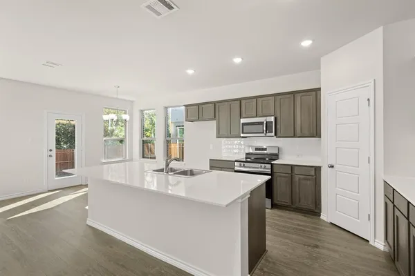 a kitchen with stainless steel appliances a sink stove and refrigerator