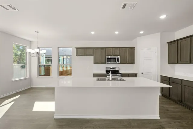 a kitchen with stainless steel appliances granite countertop a sink stove and cabinets